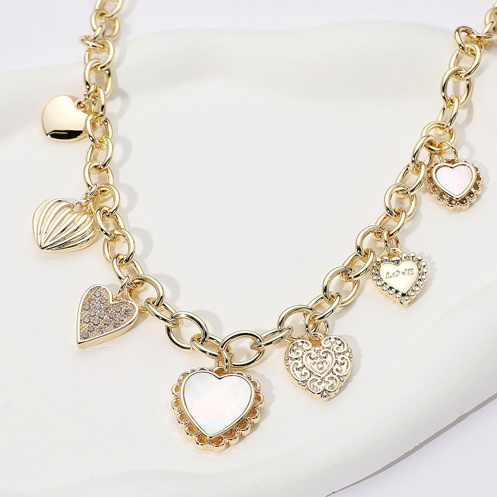 Gold necklace with heart-shaped charms on a white background