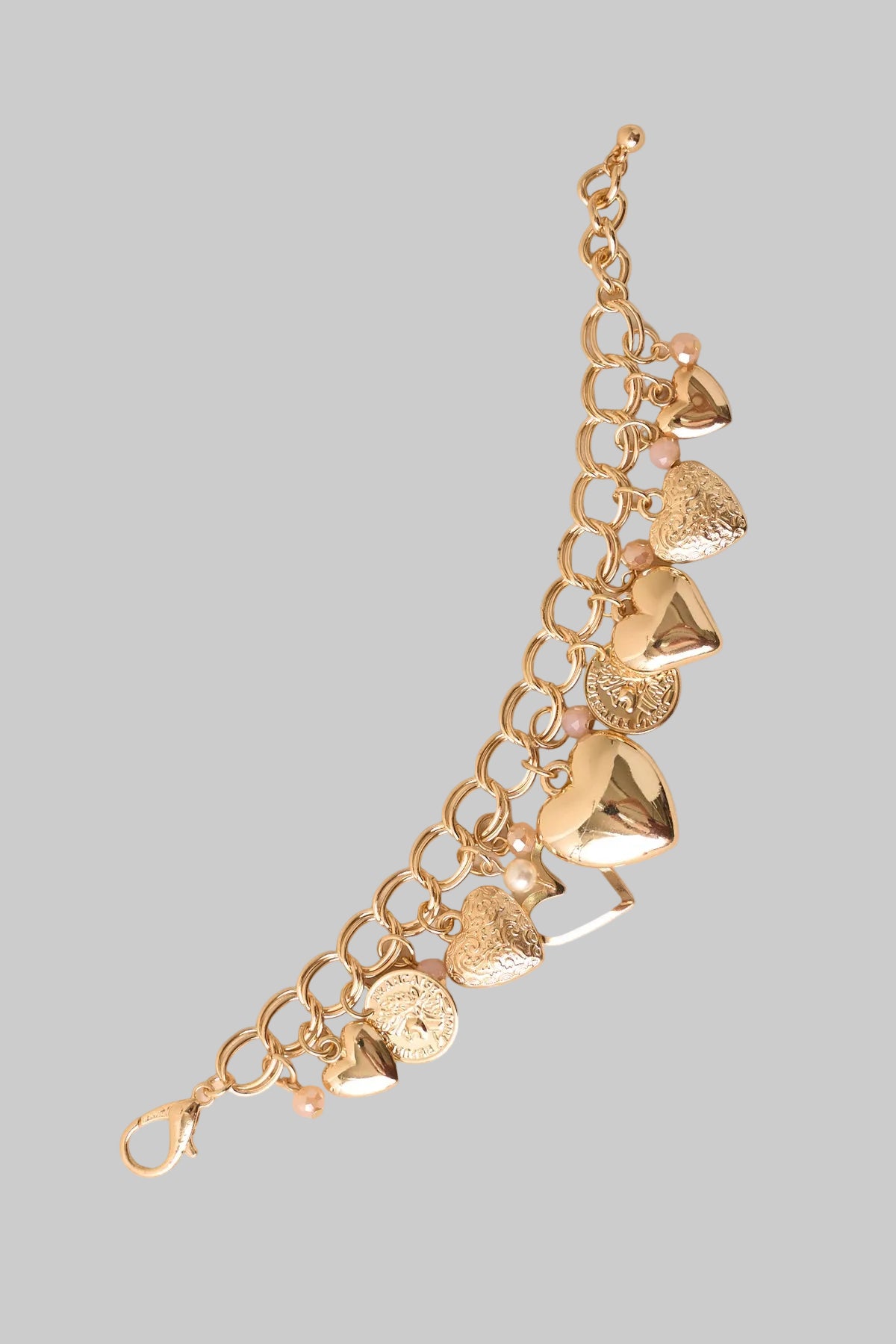 Gold bracelet with heart-shaped charms on a gray background