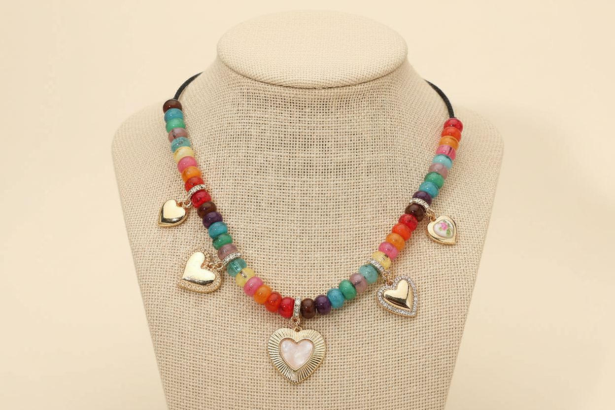 Necklace with colorful beads and heart-shaped charms on a mannequin bust.
