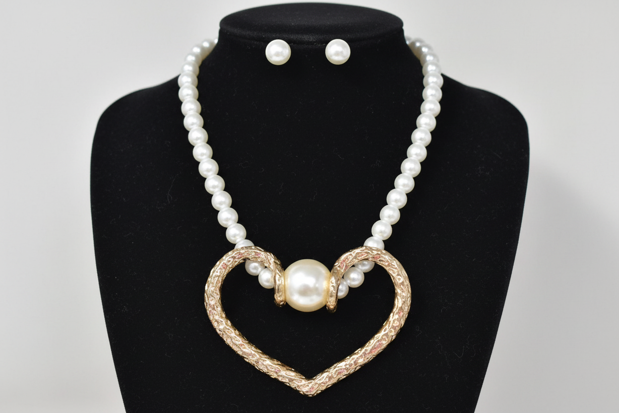 Add timeless elegance with this pearl necklace set featuring a bold heart pendant and matching stud earrings. 