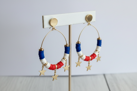 Triple Metal Star Charms Accented Dangle Beaded Disc Hoop Earrings displayed on an earring display bar with a white background. 