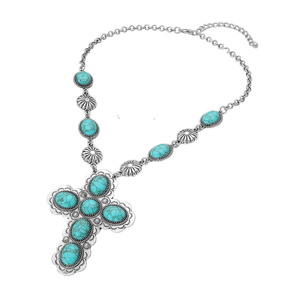 A silver-toned Southwestern-style cross pendant necklace featuring multiple oval turquoise stones, set against a plain white background.